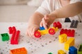 Close up of child`s hands playing with colorful plastic bricks at the table. Toddler having fun Royalty Free Stock Photo