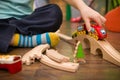 Close up on child`s hands with toy train and railway in his room. Boy playing indoors Royalty Free Stock Photo