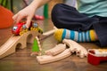 Close up on child`s hands with toy train and railway in his room. Boy playing indoors Royalty Free Stock Photo