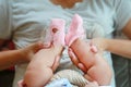 Close up the child`s legs with pink sock hold by mother