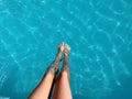 Close-up of a child`s legs sitting on a pool of crystal clear water. Summer vacation, relax. Royalty Free Stock Photo