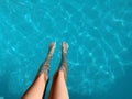 Close-up of a child`s legs sitting on a pool of crystal clear water. Summer vacation, relax. Royalty Free Stock Photo