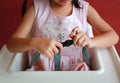 Close-up child sitting on high Chair seat with fastening safety belt locked protection byself