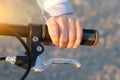 close-up of a child's hand on the bike handle. Sunny day. The idea is an active lifestyle, cycling, learning to ride a