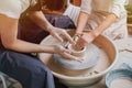 Children`s and adults`s hands together working behind the potter`s wheel Royalty Free Stock Photo