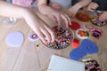 Close-up of children`s hands creating perler bead patterns, make crafts using thermomosaic technique, beading patterns, perler