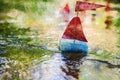 Close-up of a children`s sailboat sailing downstream