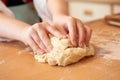 Close up of a childs hands kneeding dough on a wooden surface