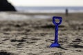 a close up of a childs spade on a cornish beach