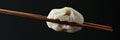 close up chinese steamed dumpling held with chopsticks Royalty Free Stock Photo