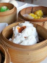 Close up Chinese steamed red pork bun is break can see pork inside in bamboo basket on table Royalty Free Stock Photo