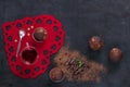 Close-up of chocolate cupcakes with spoon and tea cup on red heart-shaped board