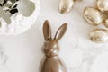 Close-up of chocolate Easter bunny with golden eggs on marble surface Royalty Free Stock Photo