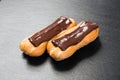 Chocolate eclairs close up on black background. Royalty Free Stock Photo