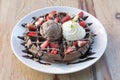 Close up of chocolate ice cream with waffle and fresh strawberry on wood table background Royalty Free Stock Photo