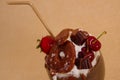 Close up of chocolate indulgent extreme milkshake with brownie cake, strawberries, cherries, and a plastic straw with Royalty Free Stock Photo