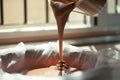 A close-up of chocolate milk liquid being poured into the form of a confectionery syringe in the form mold or mould. Preparation Royalty Free Stock Photo