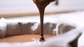 A close-up of chocolate milk liquid being poured into the form of a confectionery syringe in the form mold or mould. Preparation Royalty Free Stock Photo