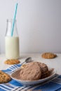 Close-up of chocolate powder falling on white plate with chocolate chip cookies, spoon, bottle of milk, with selective focus, on b Royalty Free Stock Photo