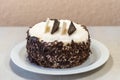 Close up of chocolate vanilla cake on a white plate. Sweets and cooking. Selective focus.