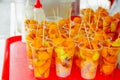 Close up chontaduro delicious amazonian tropical fruit Bactris gasipaes, inside of plastic glasses, over a red plastic