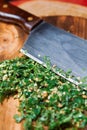 Close-up of chopped fresh green coriander or parsley leaves on a wooden cutting board