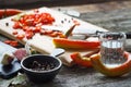 Close-up of chopped hot chili peppers and heaps of salt, sugar, garlic, allspice, bay leaf on an old wooden surface, selective