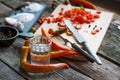 Close-up of chopped hot chili peppers and heaps of salt, sugar, garlic, allspice, bay leaf on an old wooden surface, selective