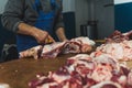 Close up of chopped pieces of meat and male hands of butcher in special gloves cutting fresh meat with knife. Meat pork Royalty Free Stock Photo