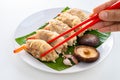 Close up Chopsticks Picking Asian Steam  Dumplings  or Dim Sum a Famous Chinese Food  with Pork and Shrimp on Banana Leaf and Royalty Free Stock Photo