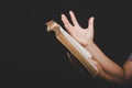 Close up of christian woman hand holding holy bible pray and worship for thank god in church with black background, adult female Royalty Free Stock Photo