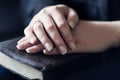 Women Holding Hands on a Bible