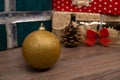 Close-up of a christmas bulb with gift boxes in background