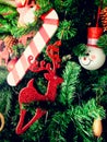 Close-up Christmas festival`s ornament for decoration, reindeer toy, snowman toy and stick toy hang on the pine tree, vertical vie Royalty Free Stock Photo