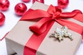 Close-up of a Christmas gift with a red ribbon and an angel next to the red Christmas balls on a white background Royalty Free Stock Photo