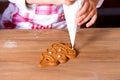 A close-up of the Christmas gingerbread in the form of a New Year tree lies on the table. Girl decorates cookies with Royalty Free Stock Photo