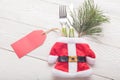 Close-up of Christmas Santa costume with fork, knife, green fir decor