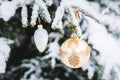 Close-up Christmas toys on a snow-covered live tree in the winter forest