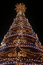 Close-up of a Christmas tree agleam with lights on black background