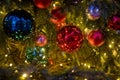 Close-up of a Christmas tree branch with decorative balls, toys and a shining garland. soft focus, background in blur Royalty Free Stock Photo
