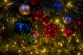 Close-up of a Christmas tree branch with decorative balls, toys and a shining garland. soft focus Royalty Free Stock Photo