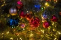 Close-up of a Christmas tree branch with decorative balls, toys and a shining garland. soft focus, background in blur. Royalty Free Stock Photo