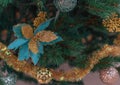 Close-up Christmas tree with Christmas decorations: golden xmas ball, snowflakes and big blue flower. Royalty Free Stock Photo
