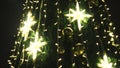 Close up of Christmas tree decorated by golden garlands and stars outdoors at nights. Concept. New year spruce tree Royalty Free Stock Photo