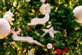 Close up Christmas tree decoration with red, gold, silver, and white balls, silver star and white reindeer. Xmas background.