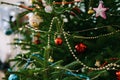 Close-up of Christmas tree decorations, garlands and beads on the branches of a Christmas tree. Royalty Free Stock Photo