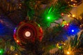 Close-up of Christmas tree with hanging red christmas ball and garland lights. New year card, selective focus Royalty Free Stock Photo