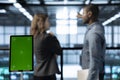 Close up of chroma key tablet in front of data center technicians in background
