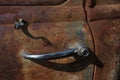 close-up of a chrome door handle of an old rusty car