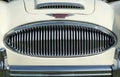 Close up of the chrome grill bumper and badge of a vintage white austin healey 300 classic sports car at hebden bridge vintage wee